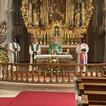 Vier Pfarrer stehen vor einem Altar in einer Kirche